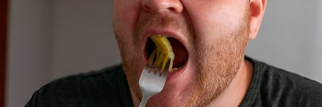 Close up of a Caucasian man eating unhealthy fast food, highlighting poor diet and nutrition habits