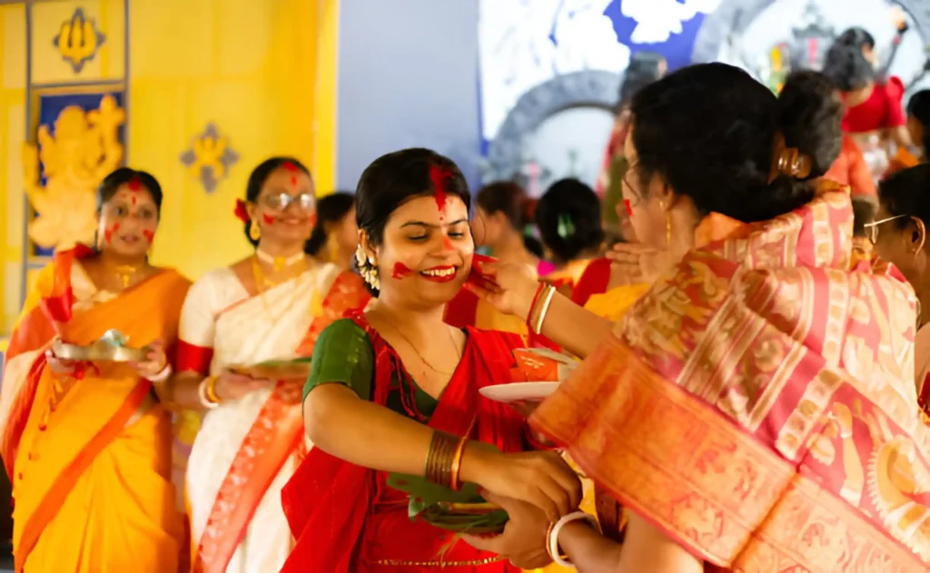 beautiful woman in traditional dress playing with sindoor during last day of Durga Puja