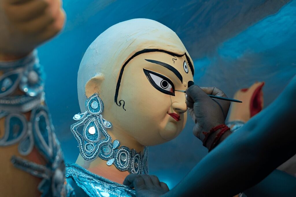 Goddess Durga idol's eyes being painted for Durga puja